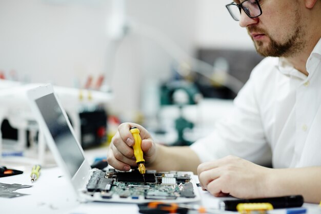 Homme assembler le circuit imprimé dans un ordinateur portable