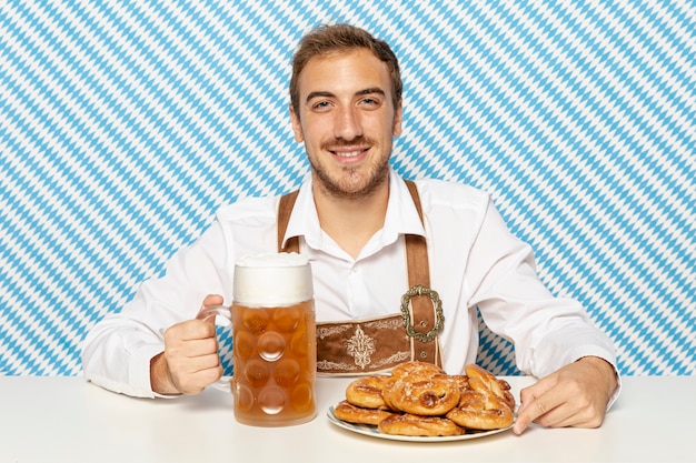 Homme avec assiette de bretzels et de bière