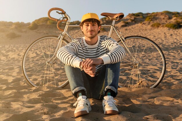 Homme assis au bord de la mer plein coup