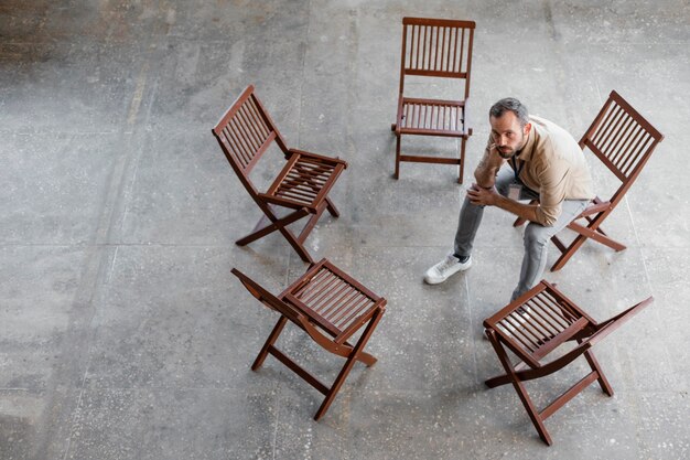 Homme assis sur une chaise plein coup