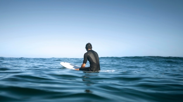 Homme assis dans l'eau du dos