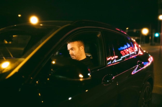 Photo gratuite homme assis dans la voiture la nuit