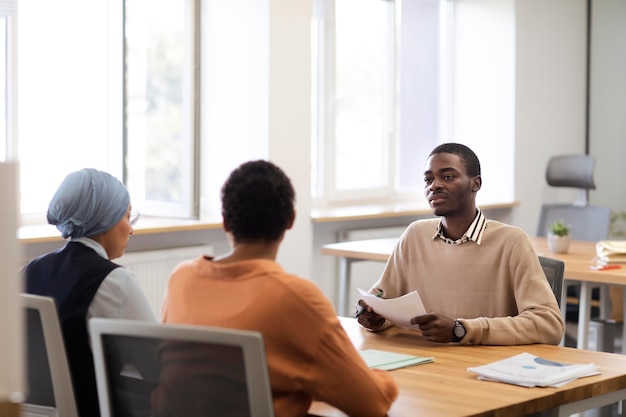 Photo gratuite homme assis pour un entretien d'embauche au bureau avec ses employeurs