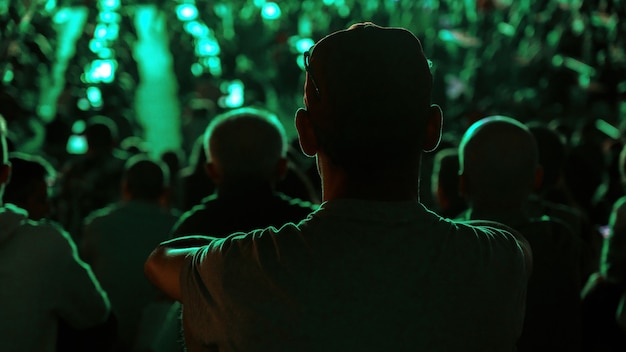 Homme assis regardant le football dans un lieu public la nuit