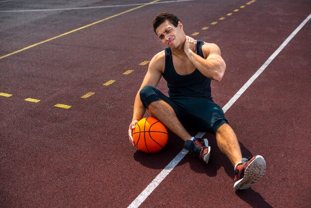 Homme assis sur le terrain de basket
