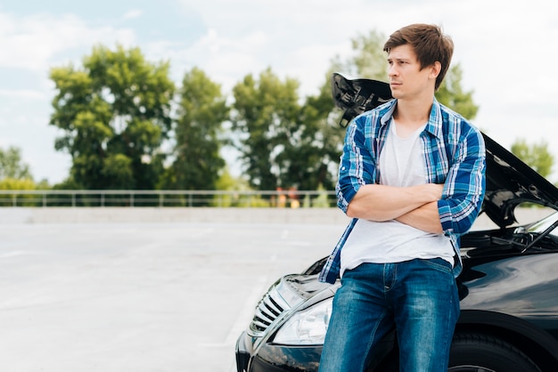 Homme assis sur la voiture avec espace de copie