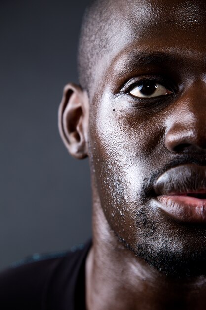 Homme athlétique courir dans un fond noir.