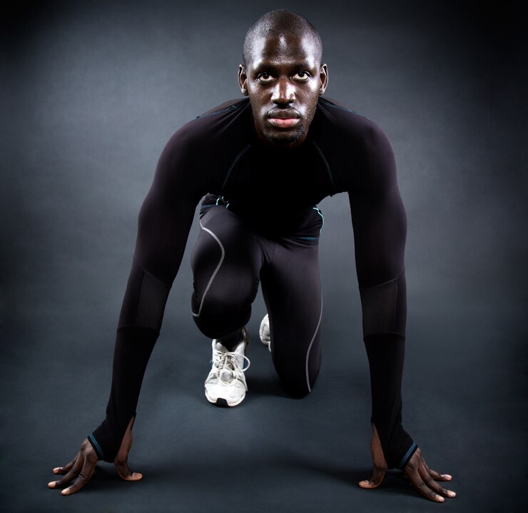 Homme athlétique courir dans un fond noir.