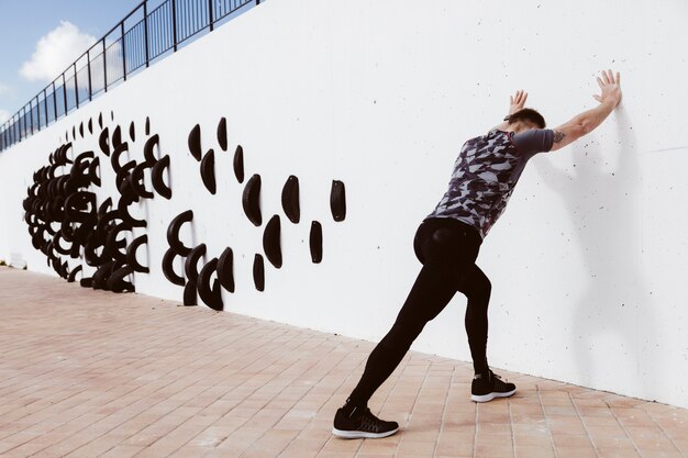 Homme athlétique faisant des pompes sur le mur