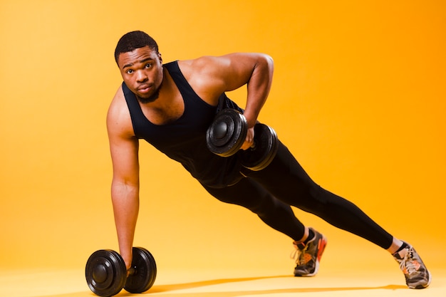 Photo gratuite homme athlétique tenant des poids pendant l'exercice