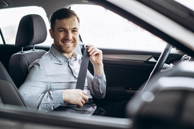 Homme attachant la ceinture de sécurité dans une voiture