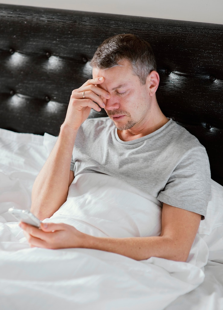 Photo gratuit homme au lit à l'aide de mobile