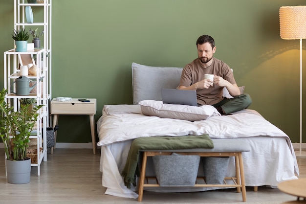 Homme au lit avec smartphone