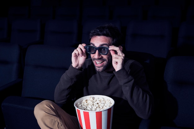 Photo gratuite homme au pop-corn au cinéma