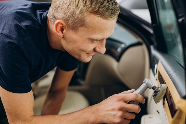 Homme au service de voiture polissant les détails de la voiture
