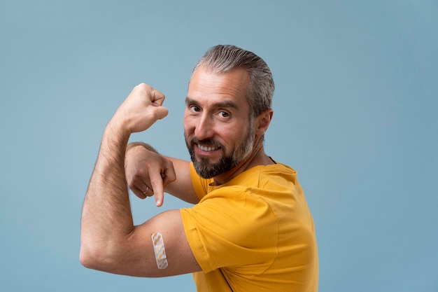 Photo gratuite homme avec autocollant sur le bras après avoir reçu un vaccin