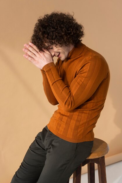 Photo gratuite homme aux cheveux bouclés avec chemisier marron posant
