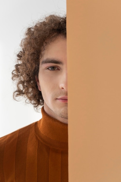 Photo gratuite homme aux cheveux bouclés avec chemisier marron posant