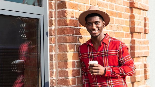 Photo gratuite homme aux cheveux courts tenant un café