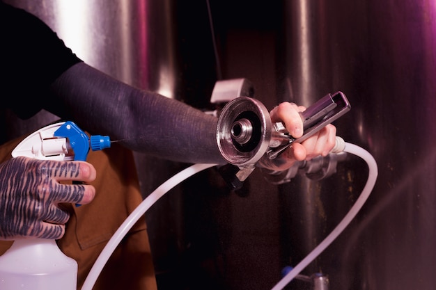 Homme aux tatouages produisant de la bière artisanale