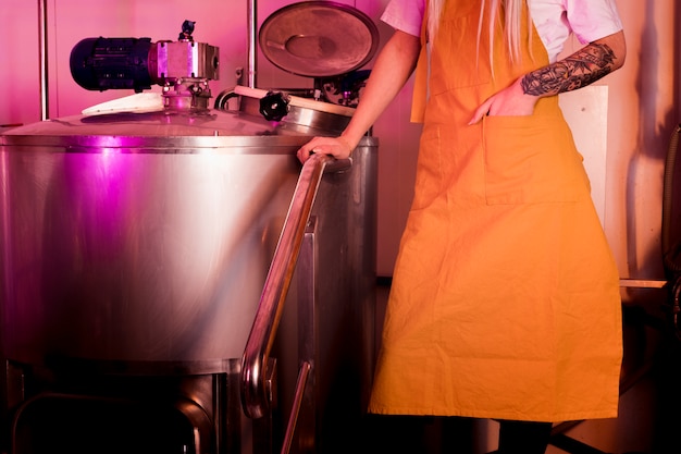 Homme aux tatouages produisant de la bière artisanale