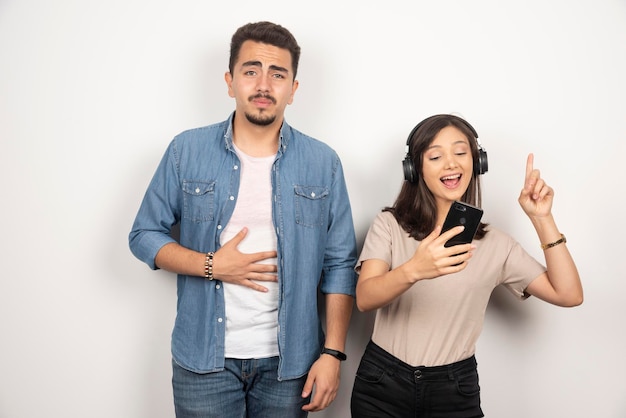 Homme ayant une panne pendant que la femme danse autour de la musique.