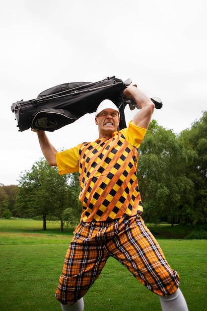 Photo gratuite homme ayant une partie de golf en plein air sur le terrain