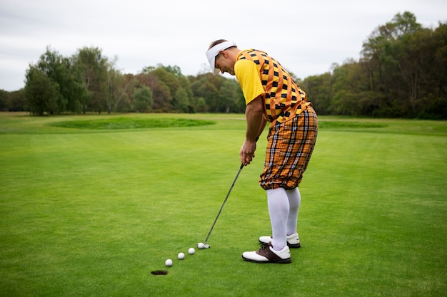 Homme ayant une partie de golf en plein air