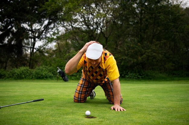Photo gratuite homme ayant une partie de golf en plein air