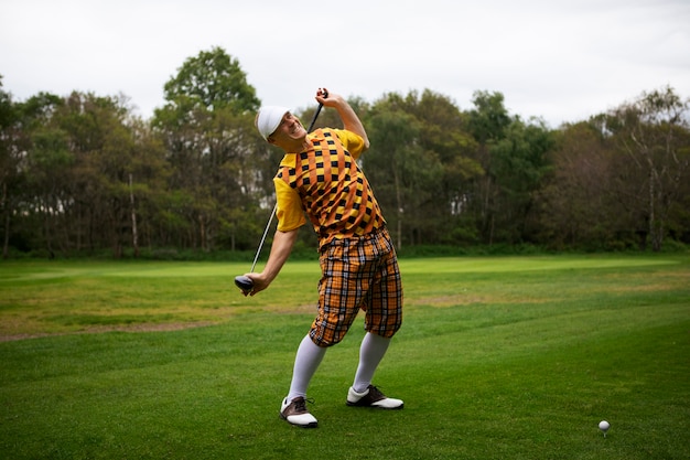 Homme ayant une partie de golf en plein air