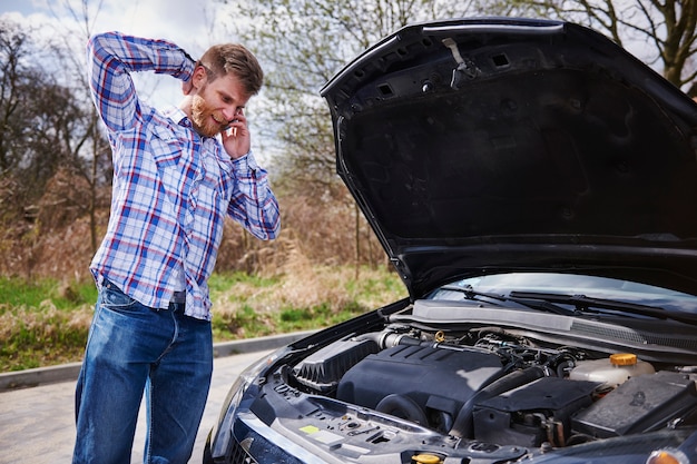 Homme ayant un problème avec sa voiture