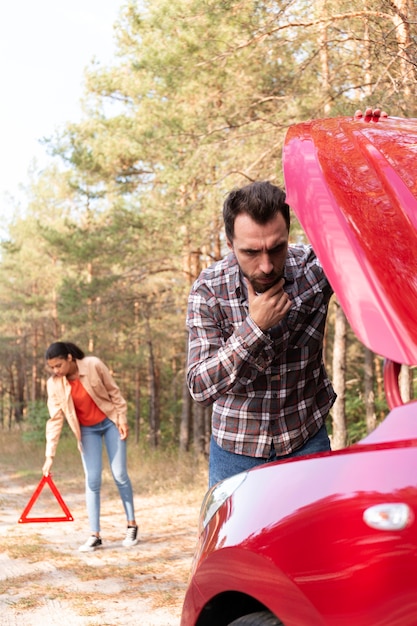 Homme ayant des problèmes avec sa voiture