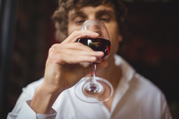 Homme ayant un verre de vin rouge