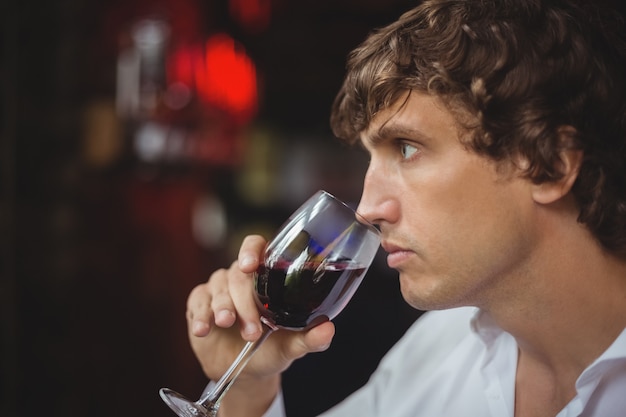 Homme ayant un verre de vin rouge