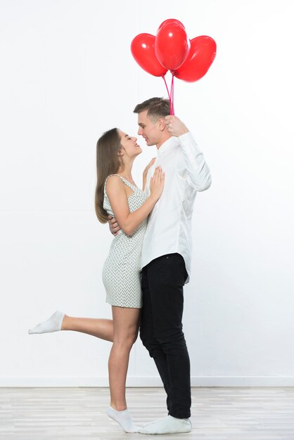 Photo gratuite homme, à, ballons coeur, étreignant femme