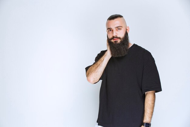 L'homme à la barbe a l'air pensif et rêveur.