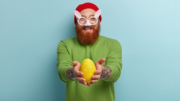 Homme à la barbe au gingembre portant des vêtements colorés et des lunettes de lapin