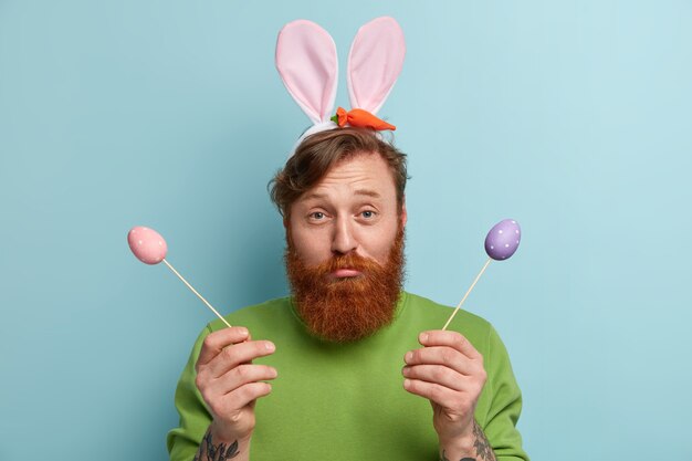 Homme à la barbe au gingembre portant des vêtements colorés et des oreilles de lapin