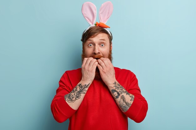 Homme à la barbe au gingembre portant des vêtements colorés et des oreilles de lapin
