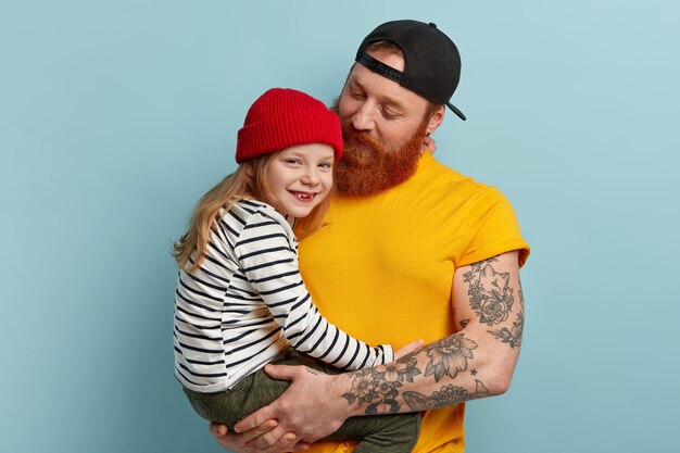 Homme avec barbe au gingembre tenant sa fille
