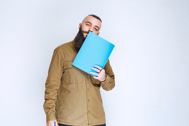 Homme à la barbe démontrant son projet et en attente d'avis.