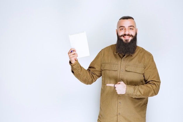 Homme à la barbe démontrant son projet et en attente d'avis.