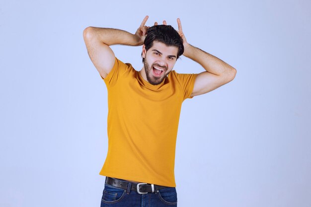 Homme à la barbe faisant signe de loup ou de lapin