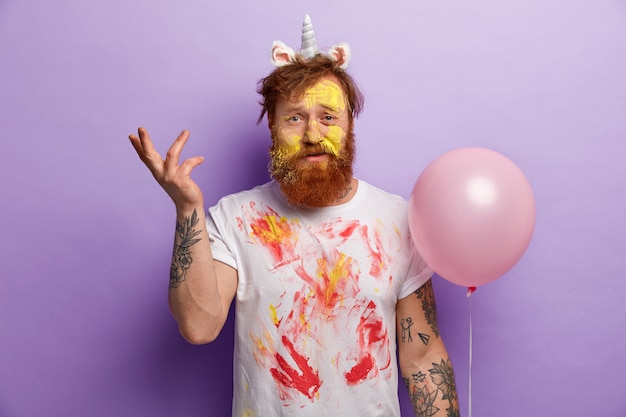 Homme à la barbe de gingembre portant un bandeau de licorne et un T-shirt sale