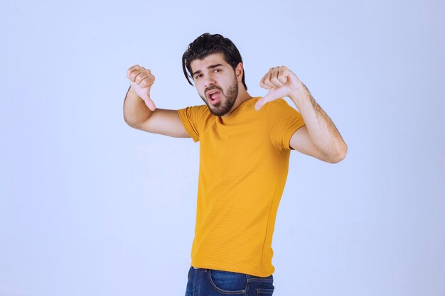 Homme à la barbe montrant le signe négatif de la main