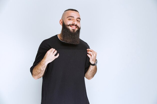 Homme à la barbe pointant sur lui-même.