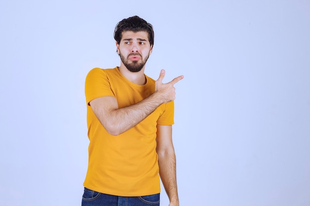 Homme à la barbe pointant vers quelque chose au-dessus