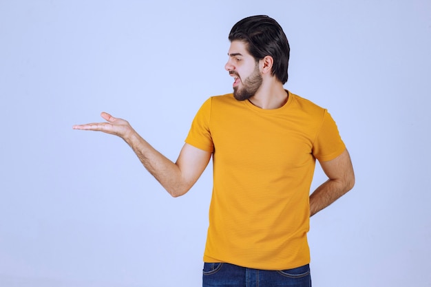 Homme avec barbe présentant quelque chose dans sa main ouverte