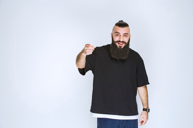 Homme à la barbe remarquant la personne devant.