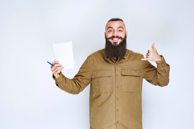 Homme à la barbe vérifiant la liste des projets et a l'air satisfait.